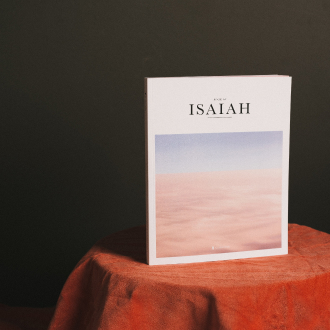 The book stands on a table with an orange tablecloth against a dark gray background